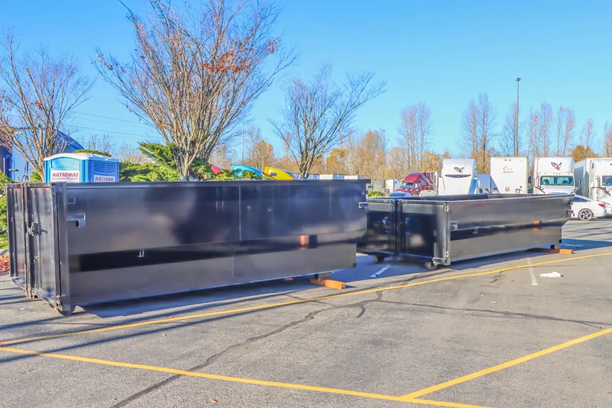 Professional dumpster rental service with roll-off container on residential driveway in West Hattiesburg